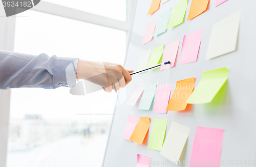 Image of close up of hand pointing to sticker on flip chart