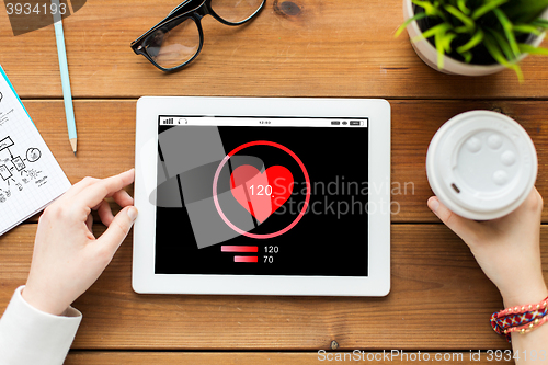 Image of close up of woman with tablet pc on wooden table