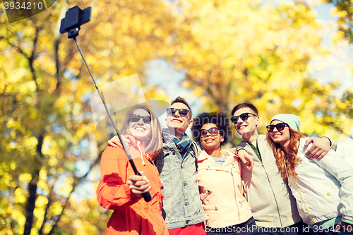 Image of smiling friends taking selfie with smartphone