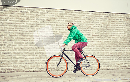 Image of young hipster man riding fixed gear bike