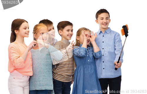 Image of happy children with smartphone and selfie stick