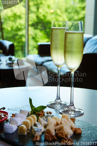 Image of two glasses of champagne with a tray cheese