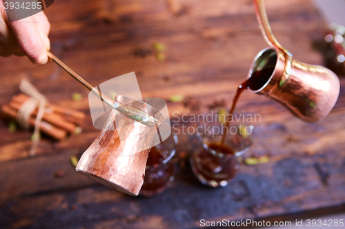 Image of To pour arabic coffee in cups on wooden background.