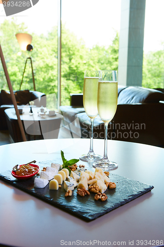 Image of two glasses of champagne with a tray cheese