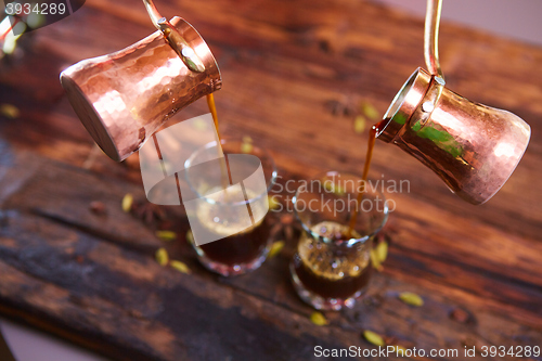 Image of To pour arabic coffee in cups on wooden background.