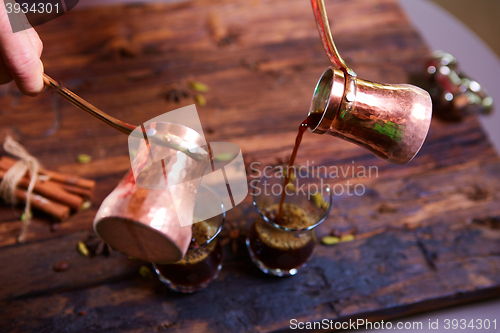 Image of To pour arabic coffee in cups on wooden background.