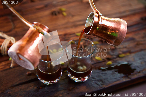 Image of To pour arabic coffee in cups on wooden background.