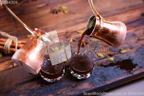 Image of To pour arabic coffee in cups on wooden background.