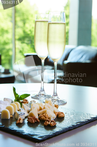 Image of two glasses of champagne with a tray cheese
