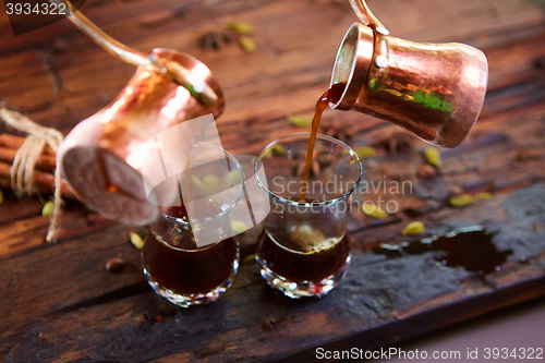 Image of To pour arabic coffee in cups on wooden background.