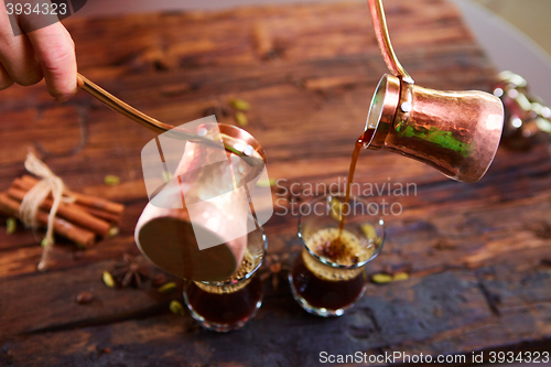 Image of To pour arabic coffee in cups on wooden background.