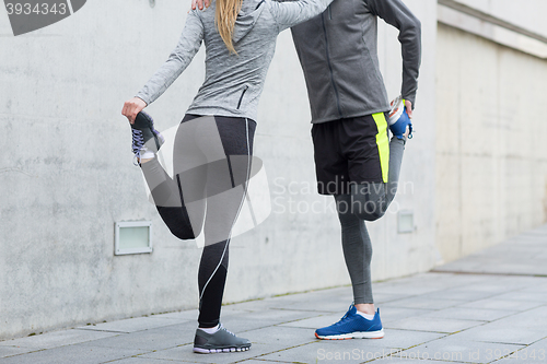 Image of close up of couple stretching legs outdoors