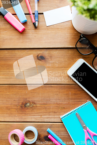 Image of close up of stationery and smartphone on table