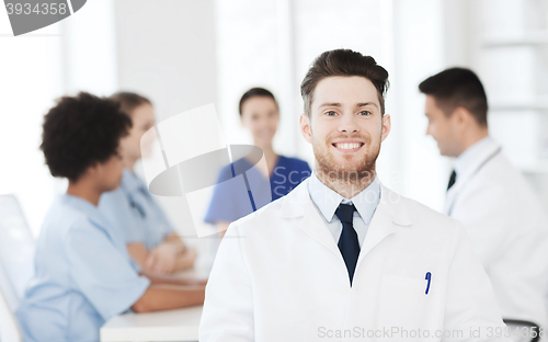 Image of happy doctor over group of medics at hospital