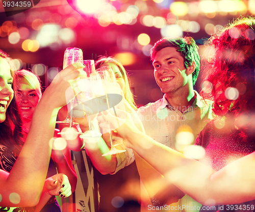 Image of smiling friends with glasses of champagne in club