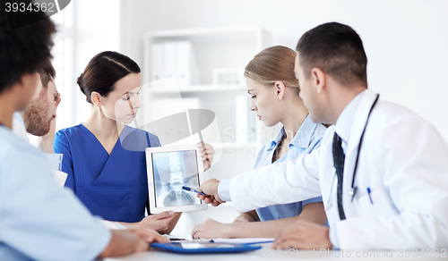 Image of group of doctors with x-ray on tablet pc at clinic