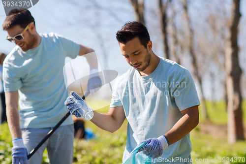 Image of volunteers with garbage bags cleaning park area