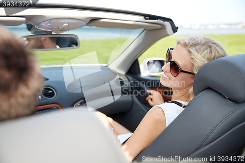 Image of happy man and woman driving in cabriolet car