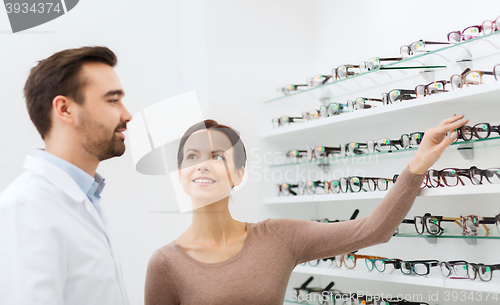 Image of woman showing glasses to optician at optics store