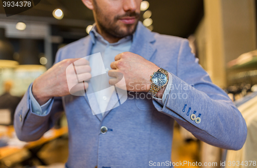 Image of close up of man trying jacket at clothing store