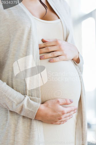 Image of close up of pregnant woman belly and hands