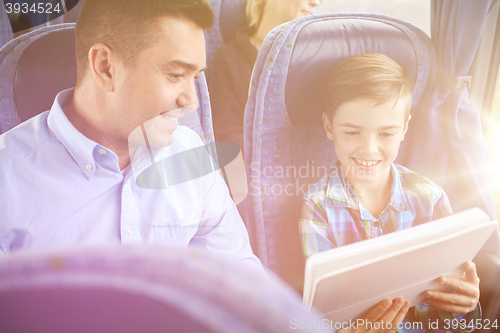 Image of happy family with tablet pc sitting in travel bus