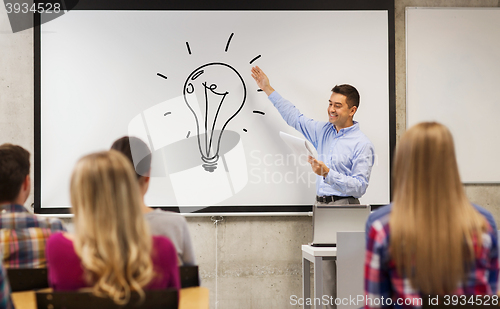 Image of group of students and happy teacher at white board