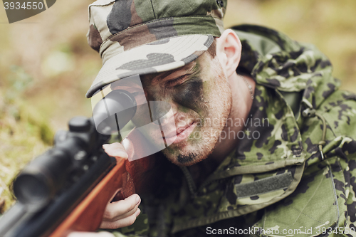 Image of soldier or hunter shooting with gun in forest