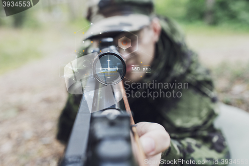 Image of close up of soldier or sniper with gun in forest