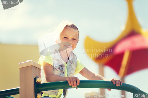 Image of happy little girl climbing on children playground