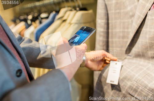 Image of close up of man with smartphone at clothing store