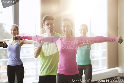 Image of happy women and trainer with dumbbells in gym