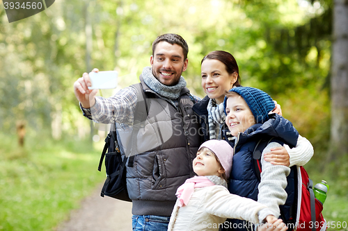 Image of family taking selfie with smartphone in woods