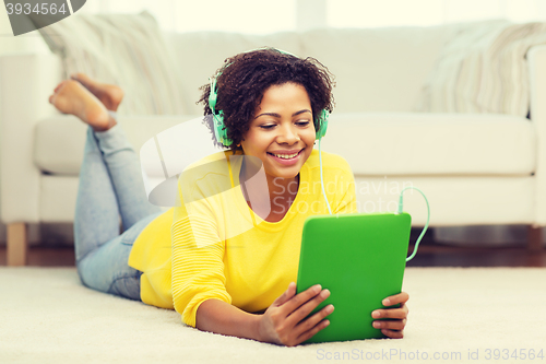 Image of happy african woman with tablet pc and headphones
