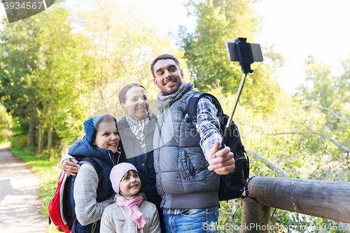 Image of family with backpacks taking selfie and hiking