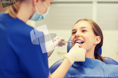 Image of female dentist checking patient girl teeth