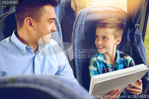 Image of happy family with tablet pc sitting in travel bus