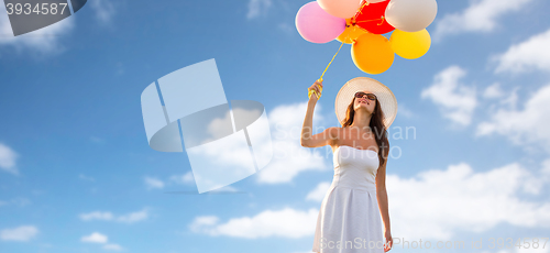 Image of smiling young woman in sunglasses with balloons