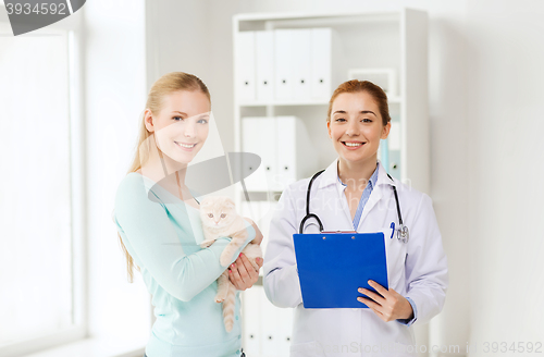 Image of happy woman with cat and doctor at vet clinic