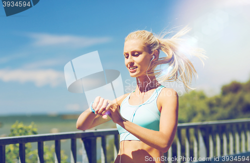 Image of happy woman with heart rate watch and earphones