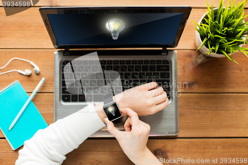 Image of close up of woman with smart watch and laptop