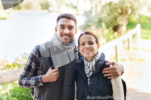 Image of happy couple with backpacks hiking and hugging