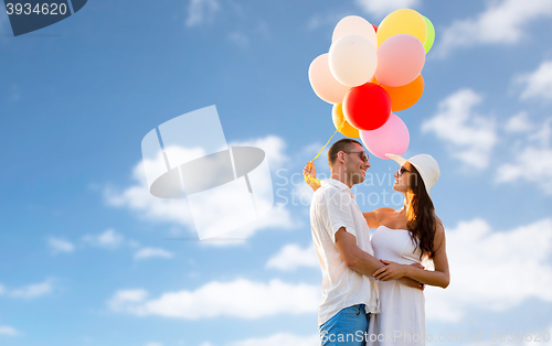 Image of smiling couple with air balloons outdoors