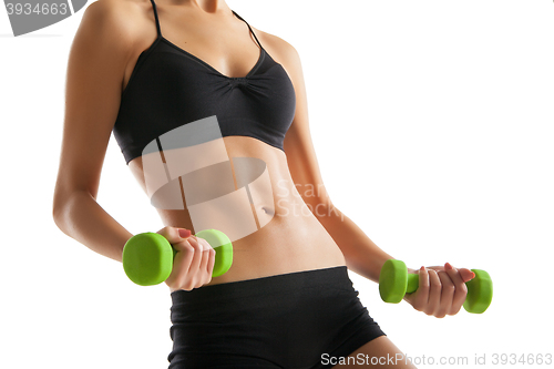 Image of Body of young fit woman lifting dumbbells