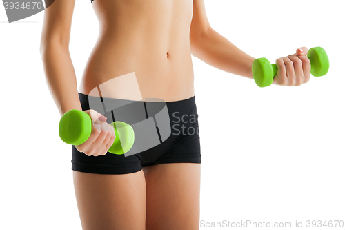 Image of Body of young fit woman lifting dumbbells