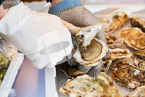 Image of Fresh oyster held open with knife in hand
