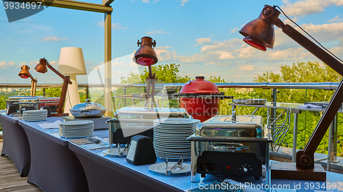 Image of Table with dishware and shiny marmites waiting for guests.