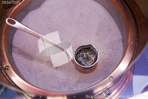 Image of Preparation of Turkish coffee in the cezve in the sand