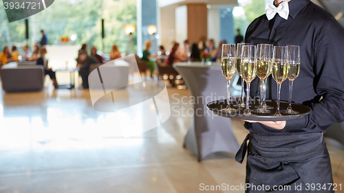 Image of Waiter serving champagne on a tray