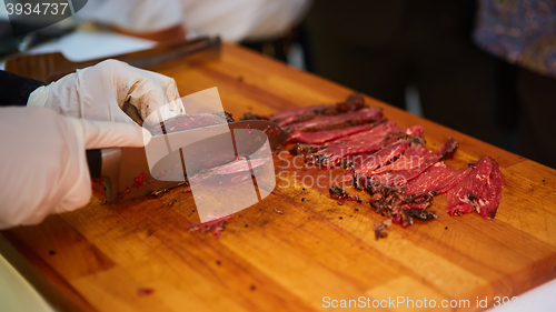 Image of Butcher cutting slices of fresh beef
